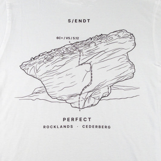 White t-shirt featuring a black line art graphic of a rock formation with a boulder on it, and text reading 'S/ENDT', 'PERFECT', and 'ROCKLANDS • CEDERBERG'.