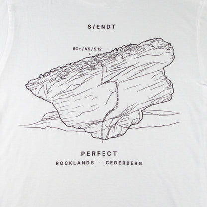 White t-shirt featuring a black line art graphic of a rock formation with a boulder on it, and text reading 'S/ENDT', 'PERFECT', and 'ROCKLANDS • CEDERBERG'.