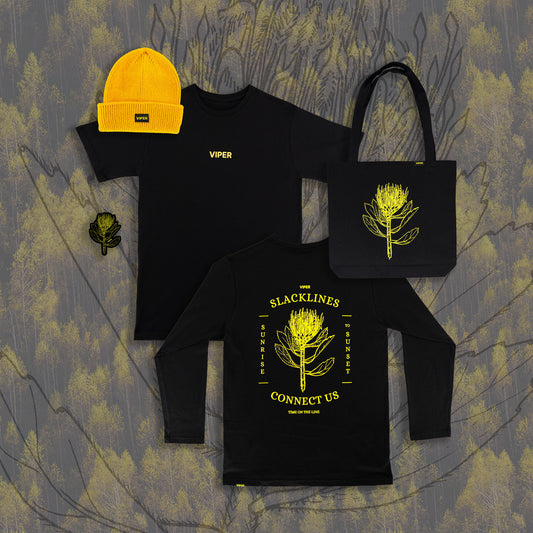 Black clothing items with yellow designs and text on a textured surface
