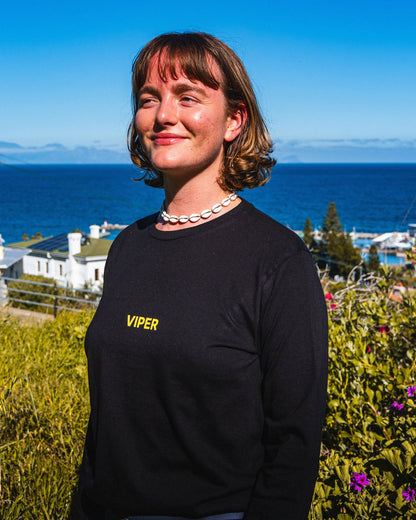 Woman wearing a black 'Viper' sweatshirt standing in front of a scenic ocean view.